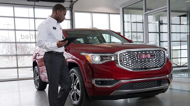Car salesman showing red GMC vehicle