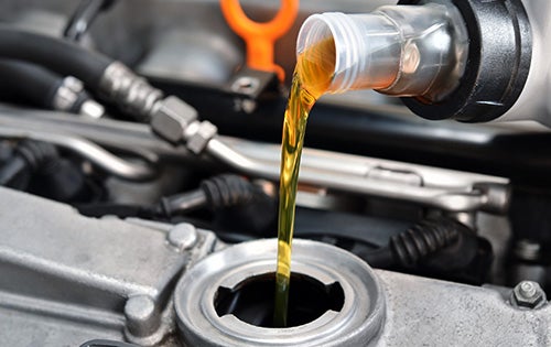 Pouring oil into car engine